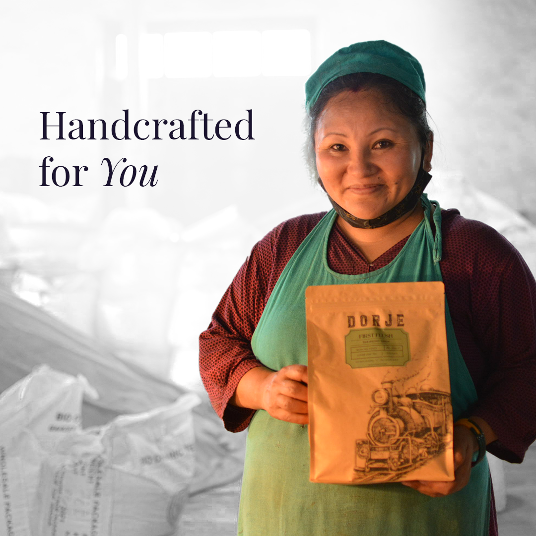 a woman in factory overalls holding a packet of Darjeeling Green Tea