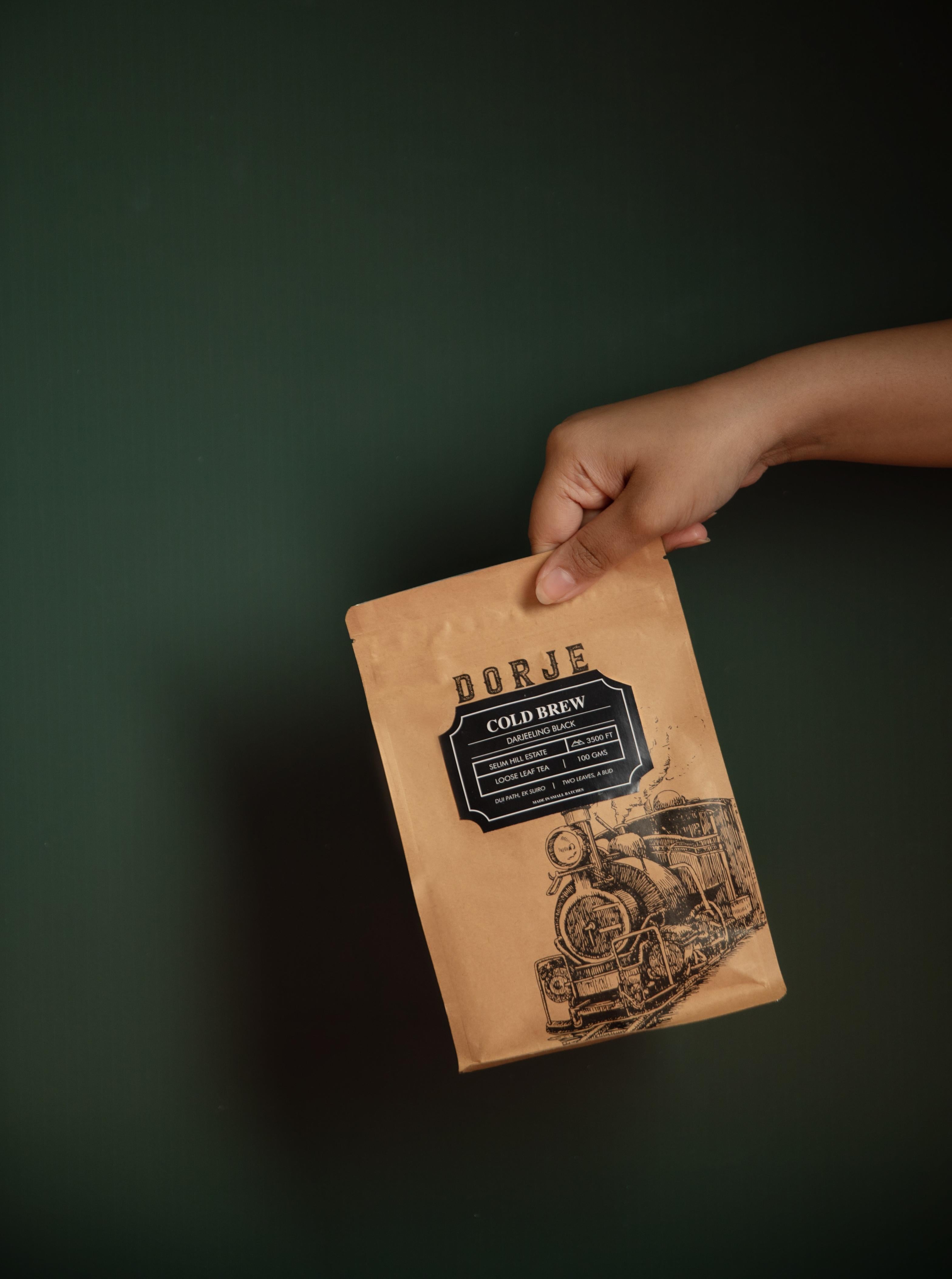 A Packet of Darjeeling Dorje Cold Brew against a dark green background