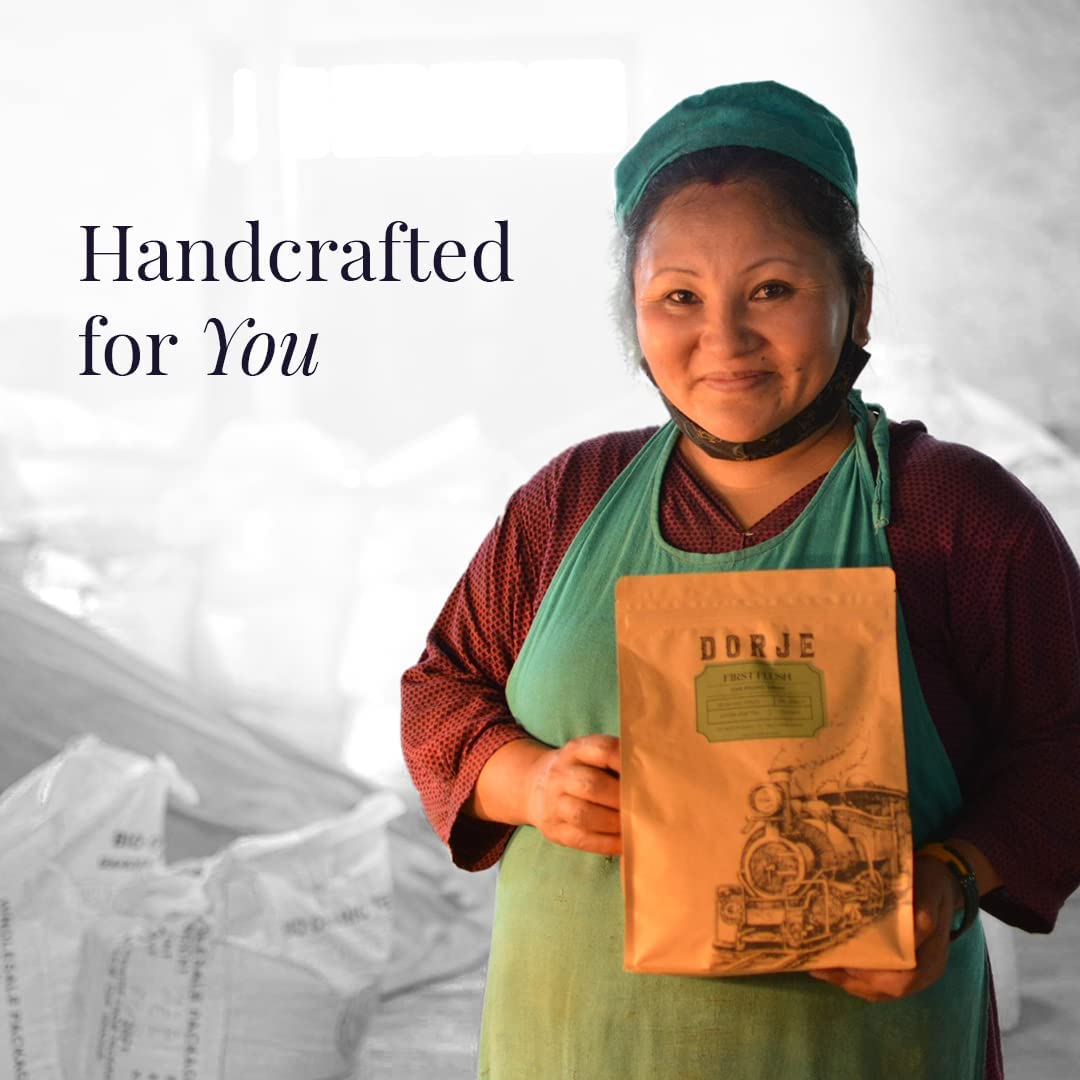 A Woman in factory overalls holding a packet of Darjeeling Teas