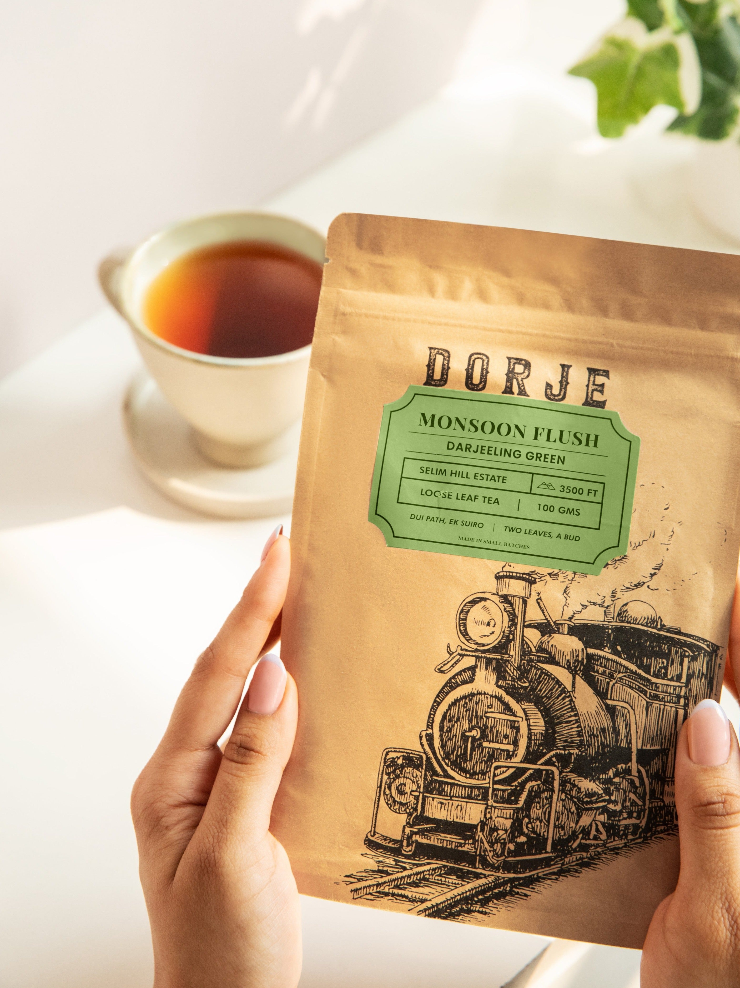 A Pair of hands holding a packet of Dorje Monsoon Flush Green tea